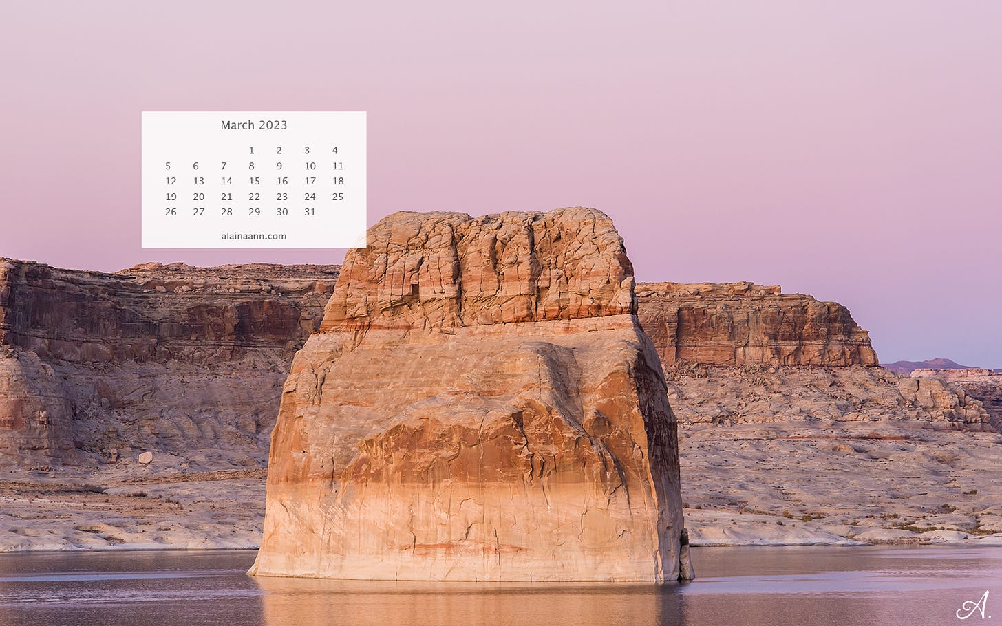 Large rock formation surrounded by still water at sunset. The sky is pastel pink and purple.