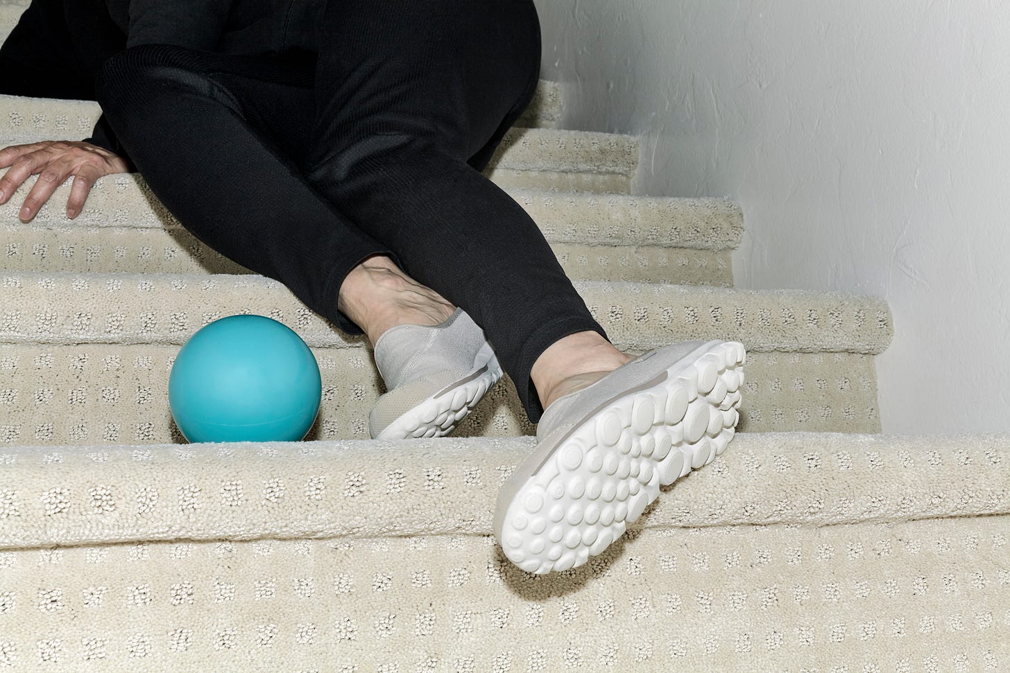 The legs of a woman who tripped over a child's ball left on the stairs