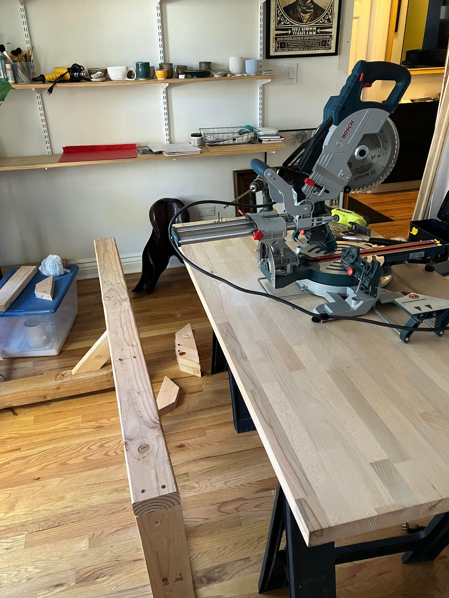 sliding compound mitre saw with 2x4s assembled on the floor in what will become a table