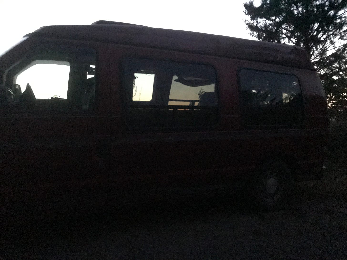 A silhouette of a van at dusk