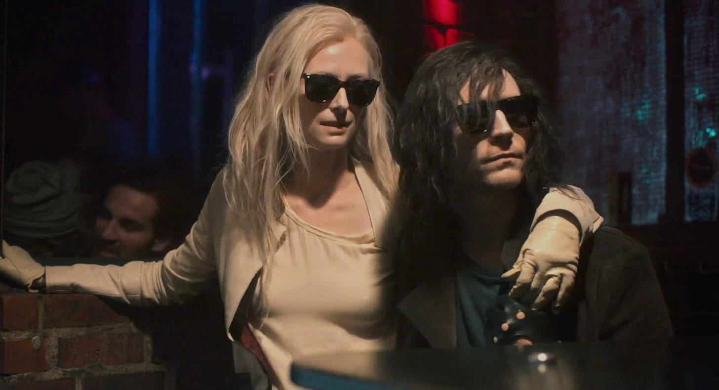 Still from Only Lovers Left Alive. Tilda Swinton drapes her arm around Tom Hiddleston. It's dark and they're wearing sunglasses.