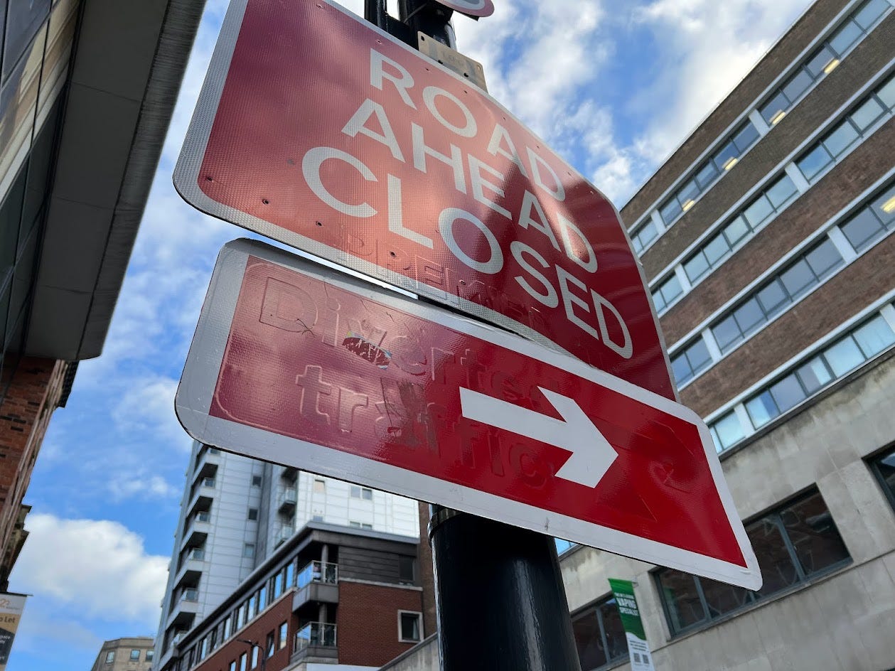Road sign showing 'Road ahead closed' with a red arrow underneath