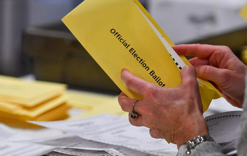Person's hands opening an official election ballot