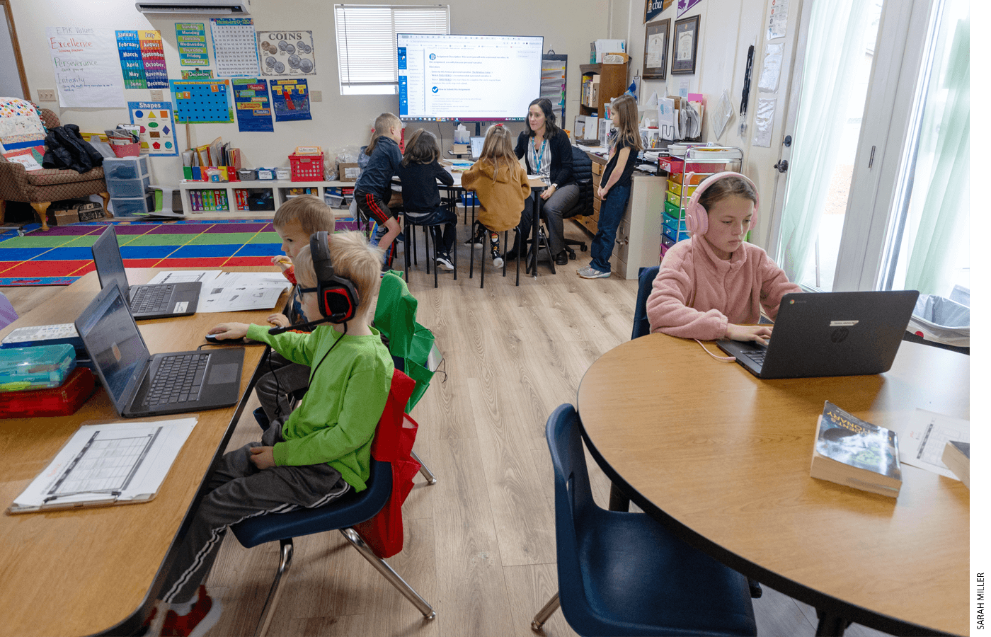 A typical school day at a Gem Prep Learning Society sees some students engaged in online lessons on laptops while others receive instruction from a teacher in a small group, all within the same classroom.