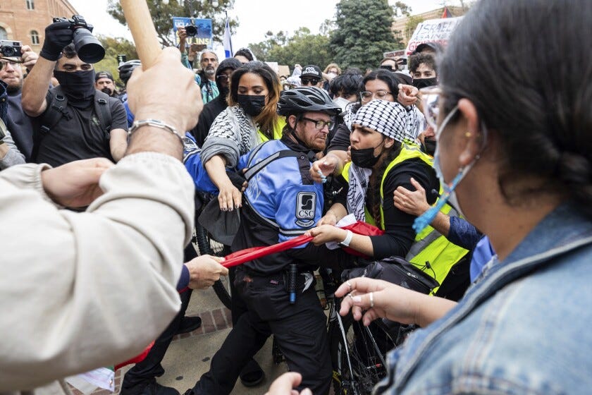 Pro-Palestinian demonstrators and Pro-Israel demonstrators clash with each other on the campus of the University of California Los Angeles (UCLA) on April 25, 2024 in Los Angeles, California. Students protesting on campuses across US ask colleges to cut investments supporting Israel. 