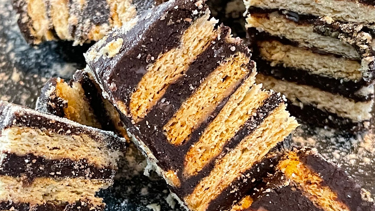 A zoomed-in view of Kalter Hund Pralinés sliced into smaller pieces, highlighting the distinct contrast between the dark chocolate layers and the golden, crisp biscuits. The powdered sugar adds a delicate touch, emphasizing the intricate details of this multi-layered treat. A zoomed-in view of Kalter Hund Pralinés sliced into smaller pieces, highlighting the distinct contrast between the dark chocolate layers and the golden, crisp biscuits. The powdered sugar adds a delicate touch, emphasizing the intricate details of this multi-layered treat.