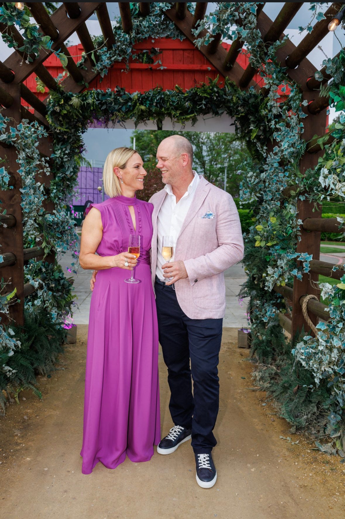 Zara and Mike Tindall smiling at each other holding wine glasses
