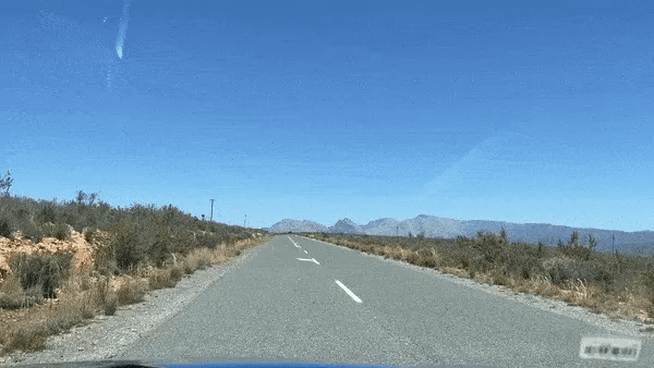 gif of a car driving along a straight road through the desert in south africa