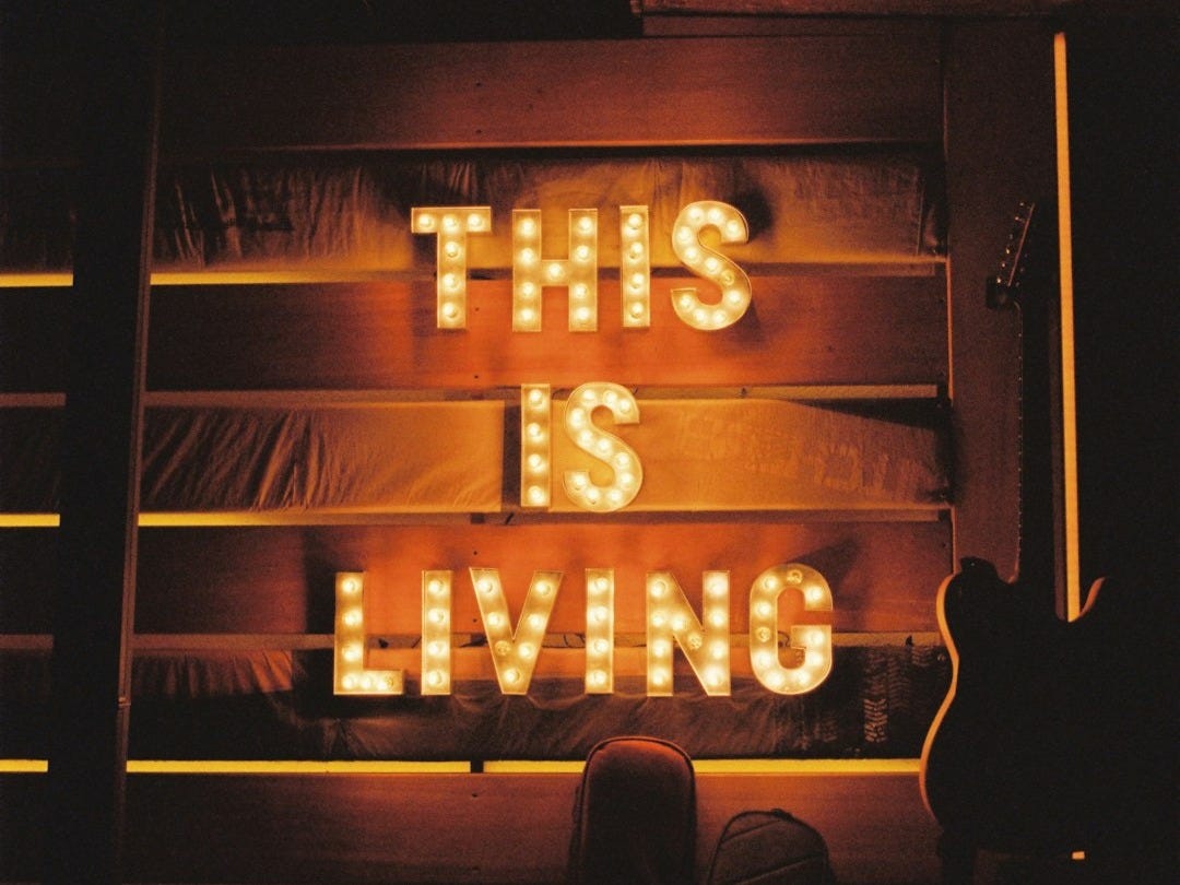 a neon sign that says this is living