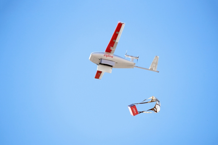 A Zipline drone drops a parachuted package out of the sky
