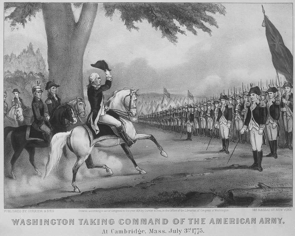 Black and white line drawing dated 1876 depicting General George Washington taking command of the Continental Army near Boston July 3, 1775. The image depicts Washington mounted on a white horse, dressed in full uniform raising his cap with his right hand in salute of the assembled ranks of troops. The officer commanding the formation holds his sword in salute to their new commanding general, George Washington. Black and white line drawing dated 1876 depicting General George Washington taking command of the Continental Army near Boston July 3, 1775. The image depicts Washington mounted on a white horse, dressed in full uniform raising his cap with his right hand in salute of the assembled ranks of troops. The officer commanding the formation holds his sword in salute to their new commanding general, George Washington.