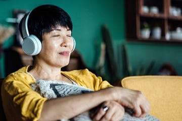 Older woman smiling and listening to headphones