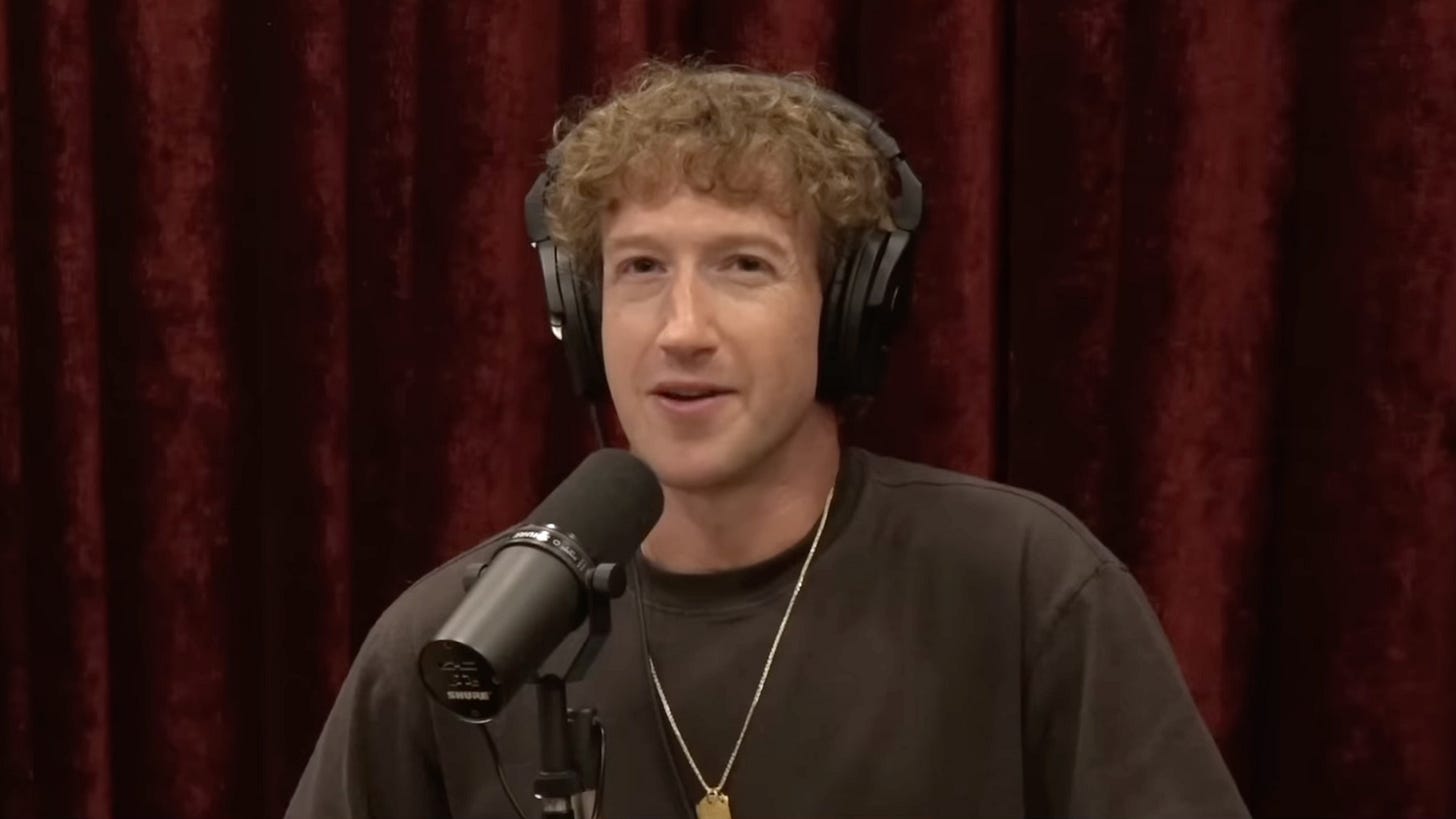 Mark Zuckerberg wearing headphones and speaking into a podcast mic