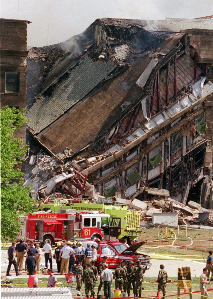 Rescue worker look over damage at the Pentagon Tuesday, Sept. 11, 2001. The Pentagon burst into flames and a portion of one side of the five-sided structure collapsed after the building was hit by an aircraft in an apparent terrorist attack. (AP Photo/Kamneko Pajic)