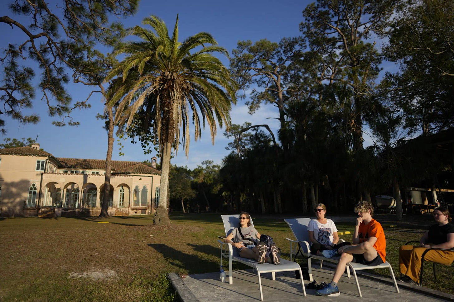 Joyce White, third from right, sits with her daughter Lola, right, son Liam, second right, and friend Eliana Salzhauer, on the waterfront at New College of Florida, where Lola is a third-year biology major with plans to be a veterinarian, Wednesday, March 1, 2023, in Sarasota, Fla. "We found this little school that was perfect for Lola," said White, whose daughter is autistic, has ADHD, and excelled at school, but found it very stressful. "Now it feels like everything has blown up." (AP Photo/Rebecca Blackwell)