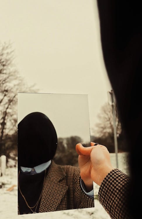 Free Man with Covered Face Reflecting in a Mirror Stock Photo