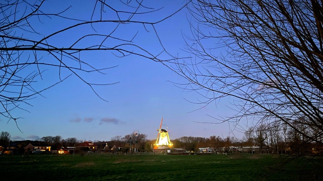 in near darkness, a typical Dutch windmill is clearly visible in the spotlights