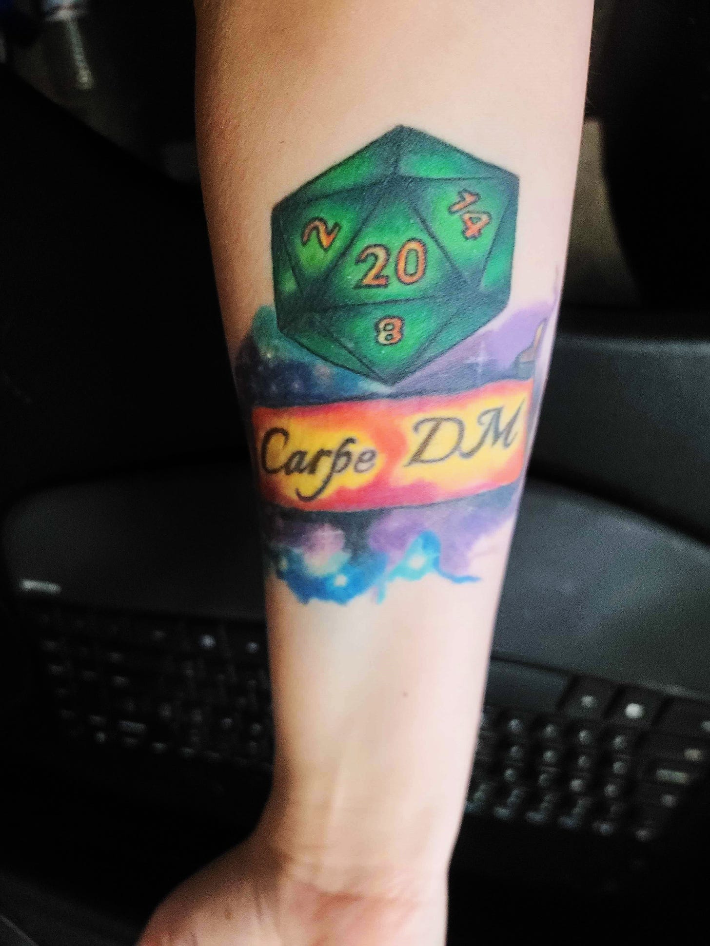 A forearm with a 20-sided die on it in green with the 20 up. Below is a banner that reads, "Carpe DM." Behind the D20 and banner is a swirl of nebula colors and stars.