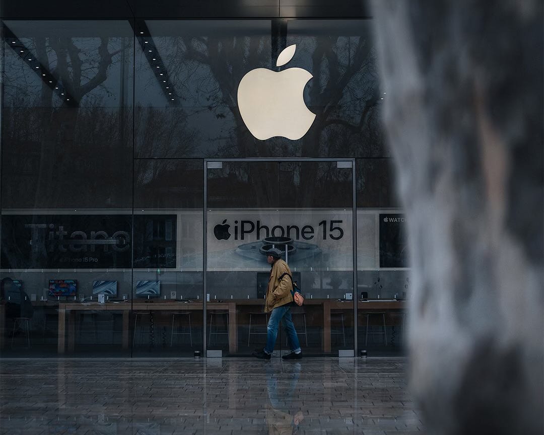 A passerby looks inside Apple Apple Aix-en-Provence on a dreary day.