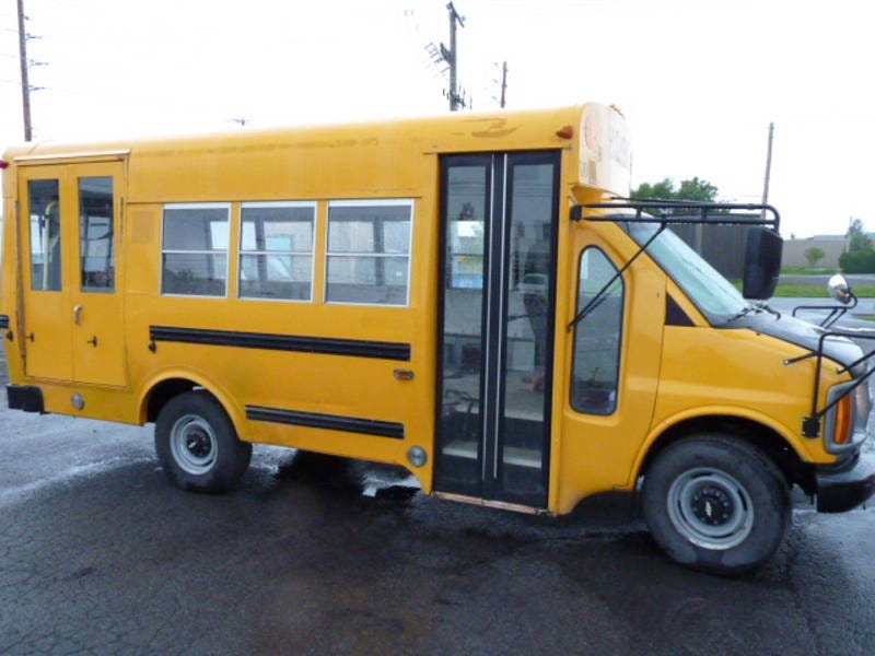 Short, yellow schoolbus in parking lot