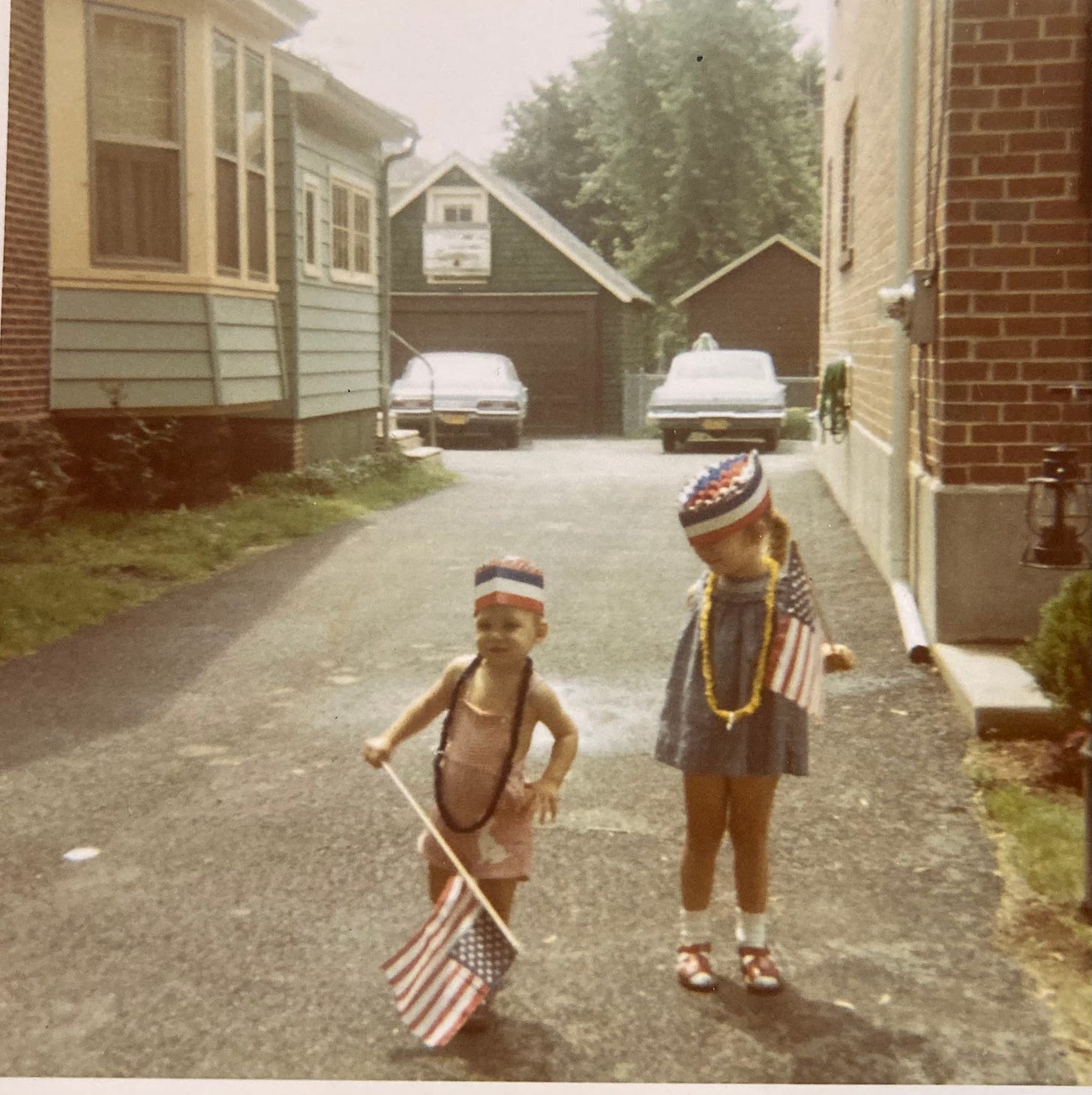 Two young children on the Fourth of July in their driveway