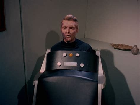 Still photo from TV show Star Trek showing a man's head atop a robot-like body that has only a few lights on the front. 