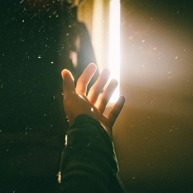 Image of a hand stretched out with sunlight shining on the hand.