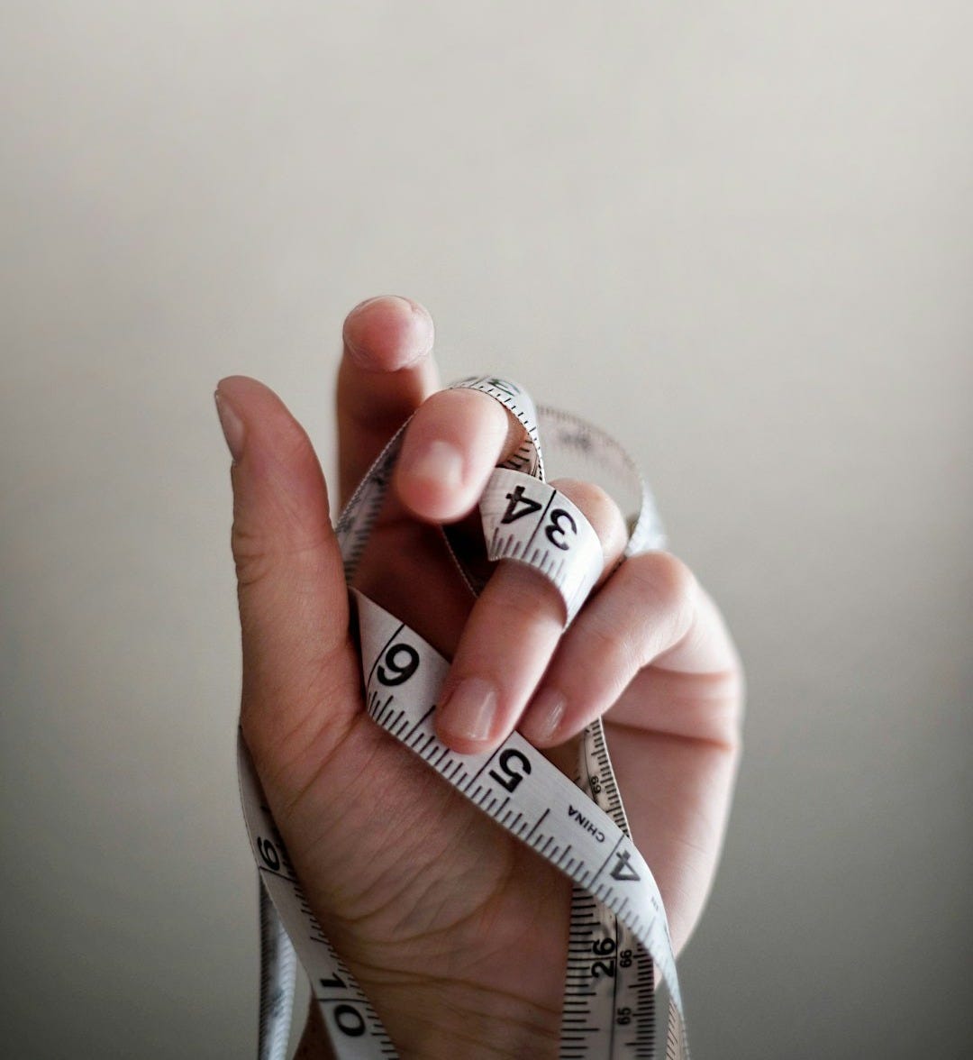person's left hand wrapped by tape measure