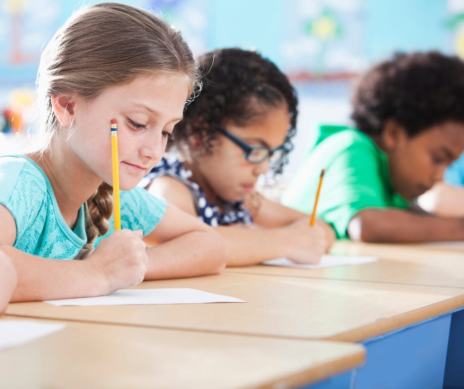 Elementary school children writing in classroom