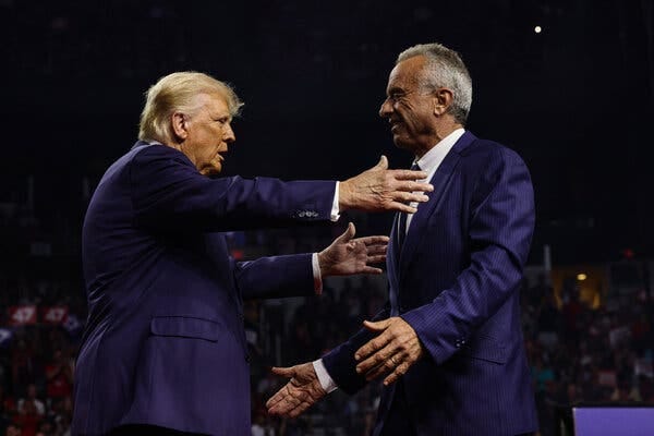 Two men in blue suits reach out towards each other.