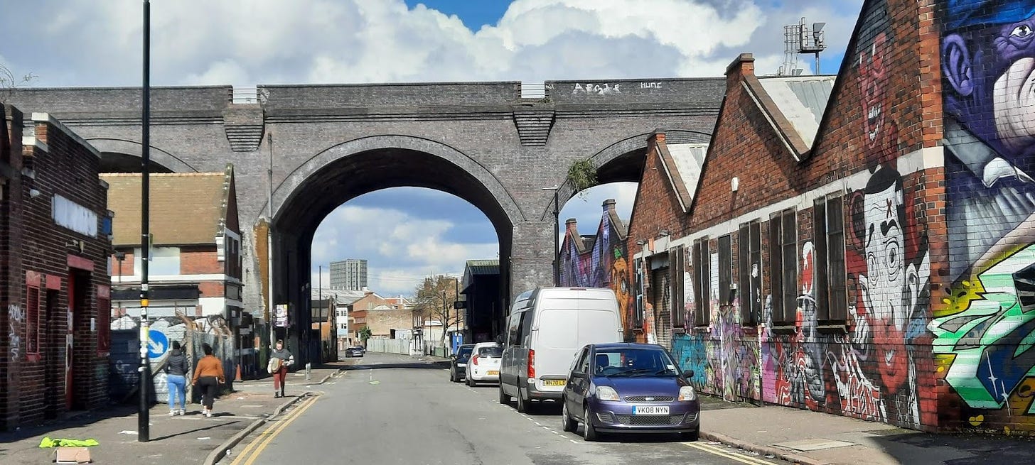 A grey brick railway bridge and graffiti