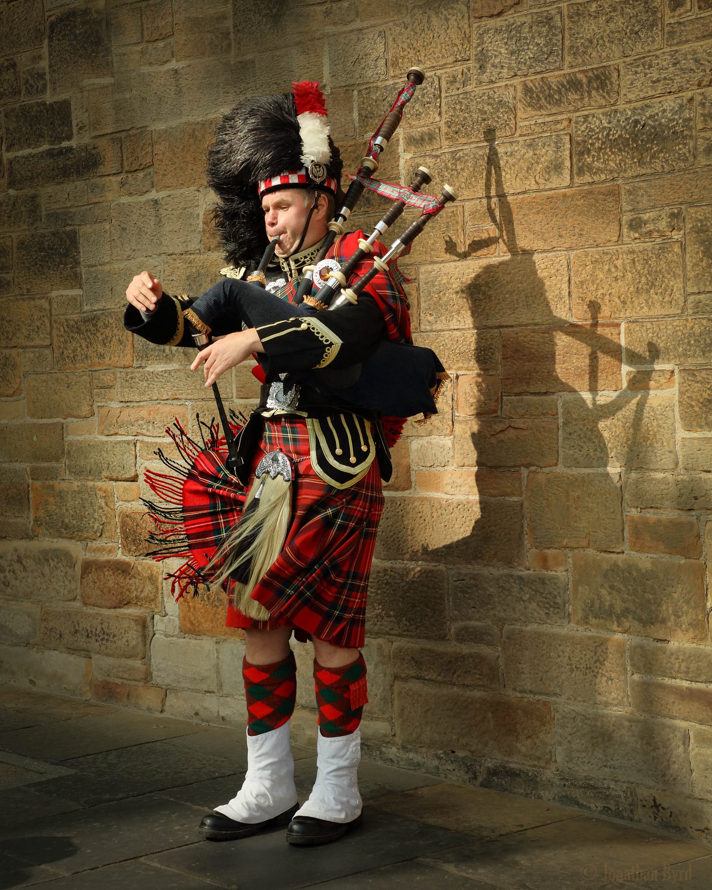 a bagpiper plays on a windy day in Edinburgh