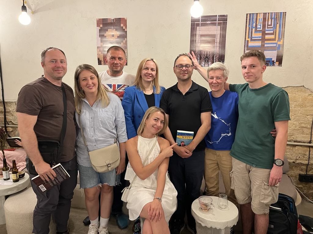 A group of friends gather around to celebrate the publication of a friend's book.