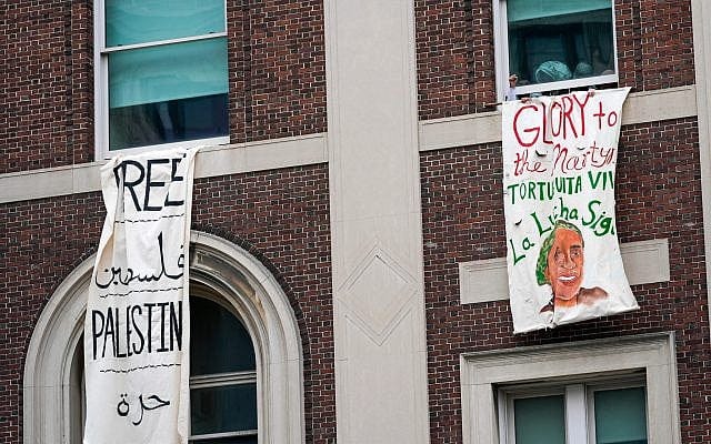 An anti-Israel demonstrator pumps his fist as he hangs a sign reading 'Glory to the Martyrs' from a window in Hamilton Hall inside the Columbia University campus, April 30, 2024, in New York. (AP Photo/Mary Altaffer) An anti-Israel demonstrator pumps his fist as he hangs a sign reading 'Glory to the Martyrs' from a window in Hamilton Hall inside the Columbia University campus, April 30, 2024, in New York. (AP Photo/Mary Altaffer)
