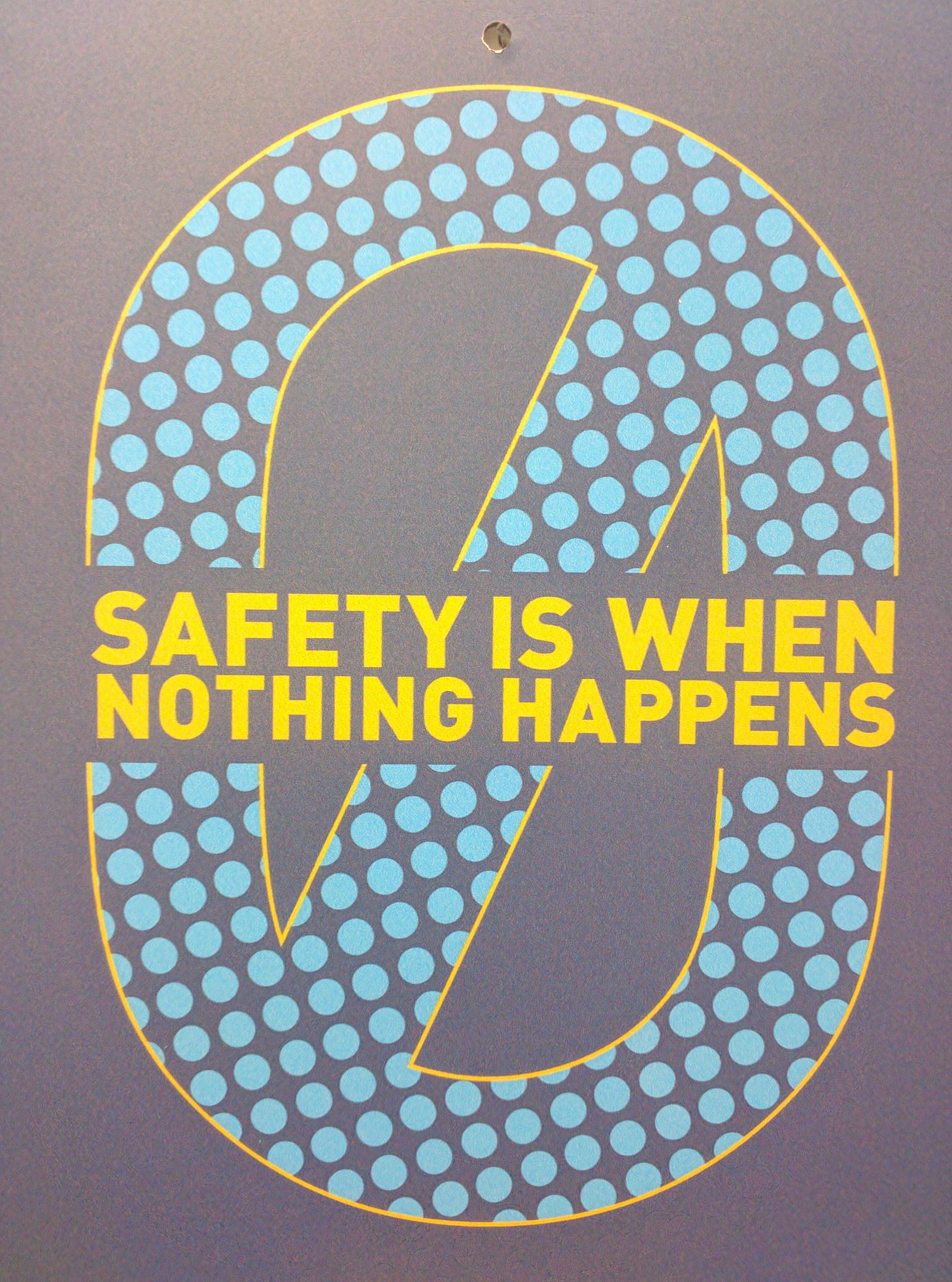 A sign with a circle with line and the text "Safety is when nothing happens"