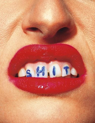 This may contain: a woman's mouth with the word shut painted on it and teeth in blue