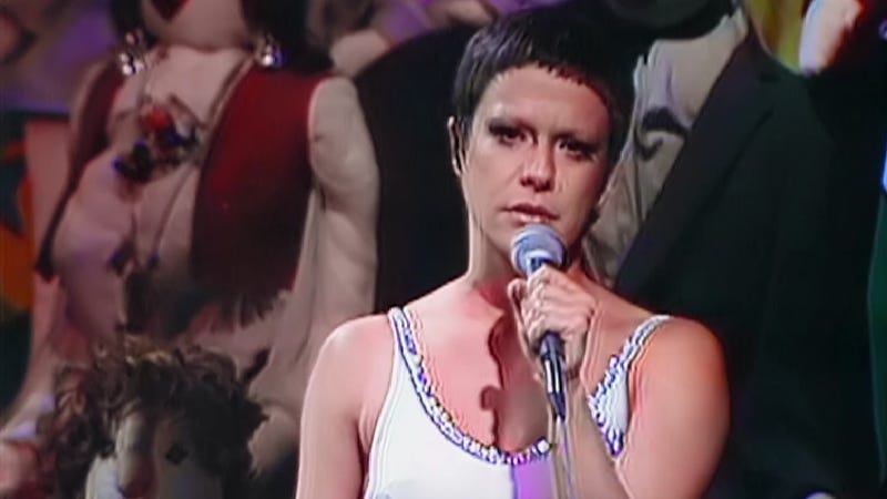 imagem da cantora elis regina, de cabelos curtos segurando um microfone