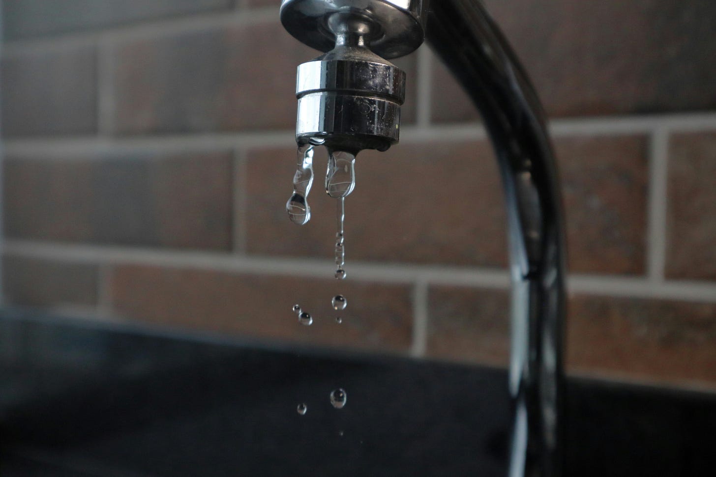 A silver faucet dripping water.