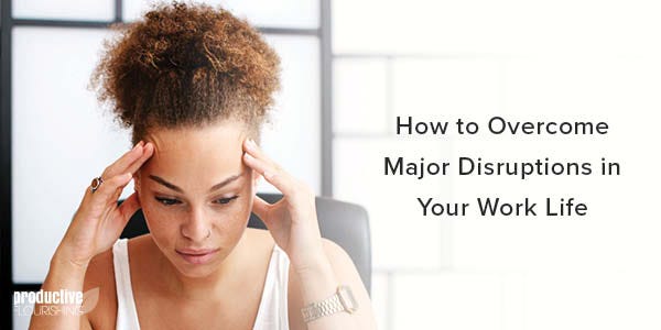 A woman sits with her fingers on her temples, looking stressed out. Text Overlay: How to Overcome Major Disruptions in Your Work Life