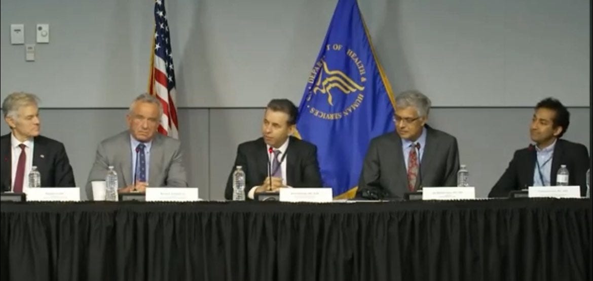 Dr. Oz, RFK Jr., Marty Makary, Jay Bhattacharya, and Vinay Prasad sitting at a table in front of an American flag and the HHS flag
