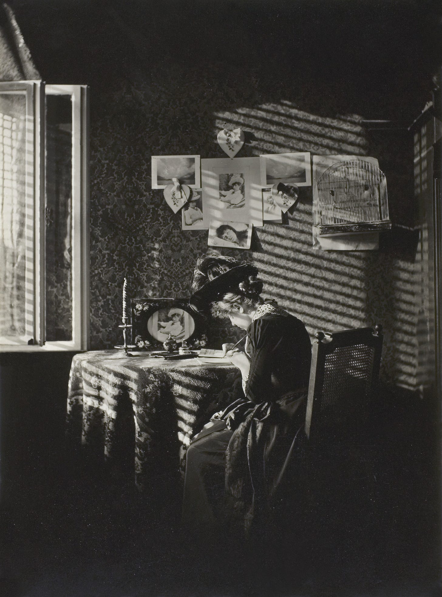 Photograph in black and white of woman writing at a desk