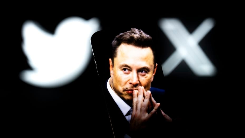 An effigy of Elon Musk is seen on a mobile device with the X and Twitter lgoso in the background in this photo illustration on 23 July, 2023 in Warsaw, Poland. (Photo by Jaap Arriens/NurPhoto via Getty Images)