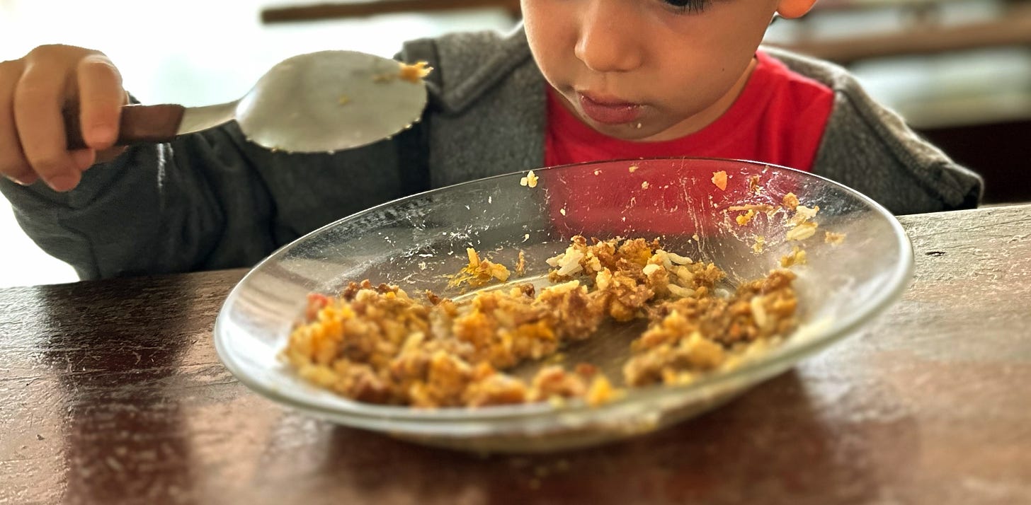 criança comendo prato de matula em restaurante