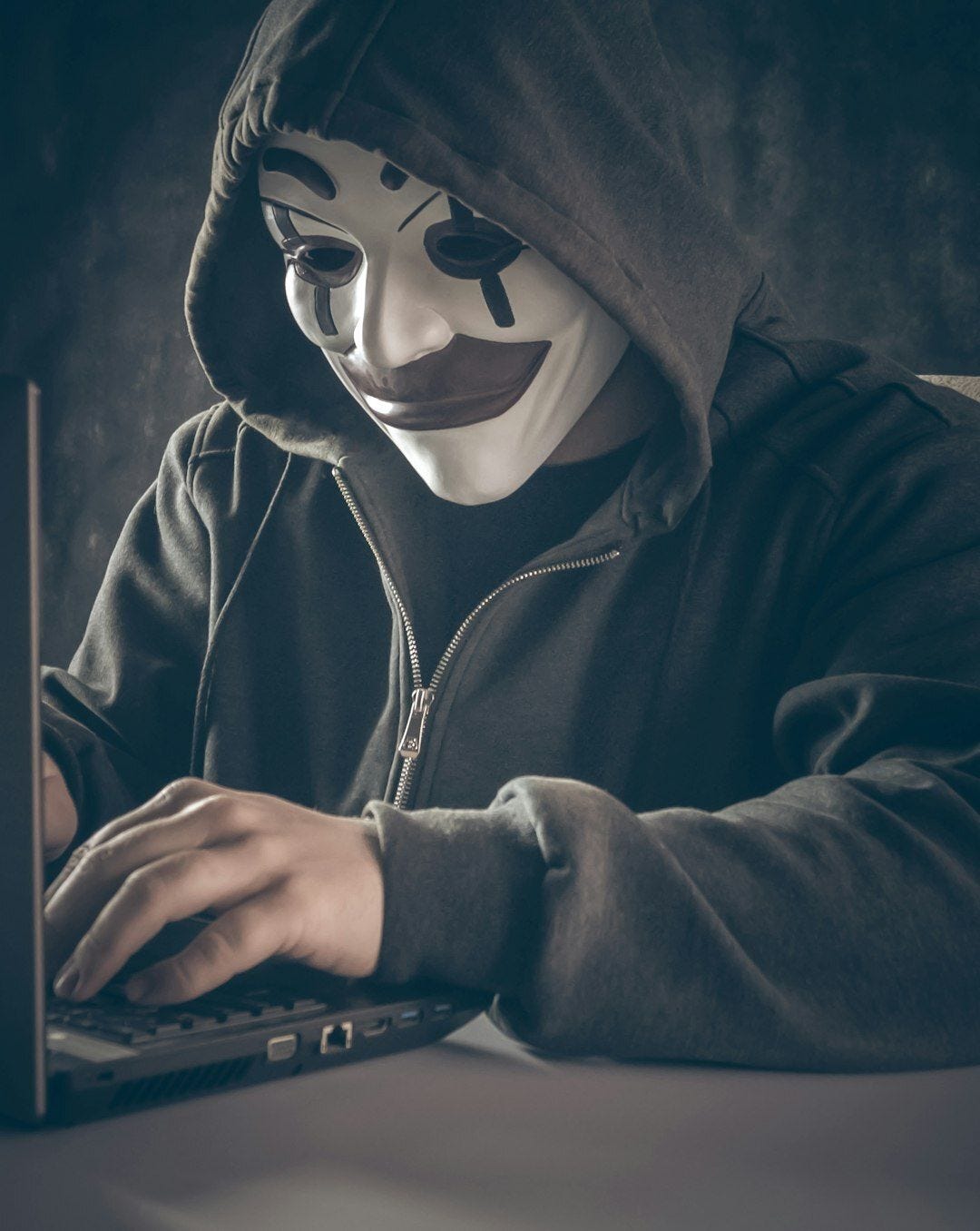 a person wearing a mask using a laptop a person wearing a mask using a laptop