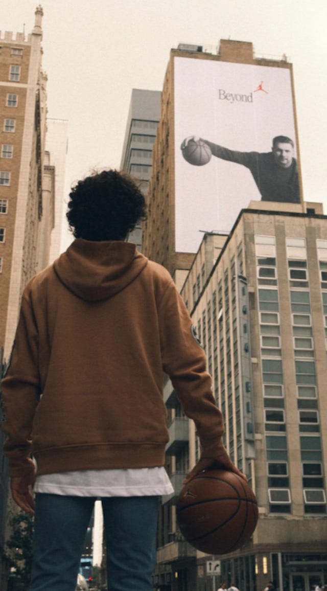 A boy looking up at a Nike billboard