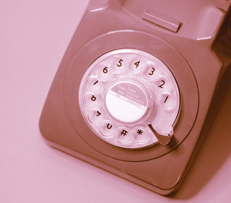 photo of rotary phone with pink tint