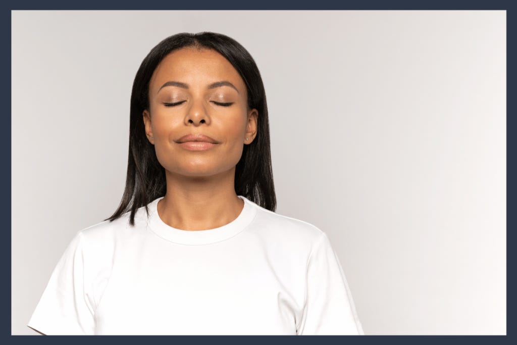 A young woman with eyes closed and relaxed smile practicing affirmations for mindfulness