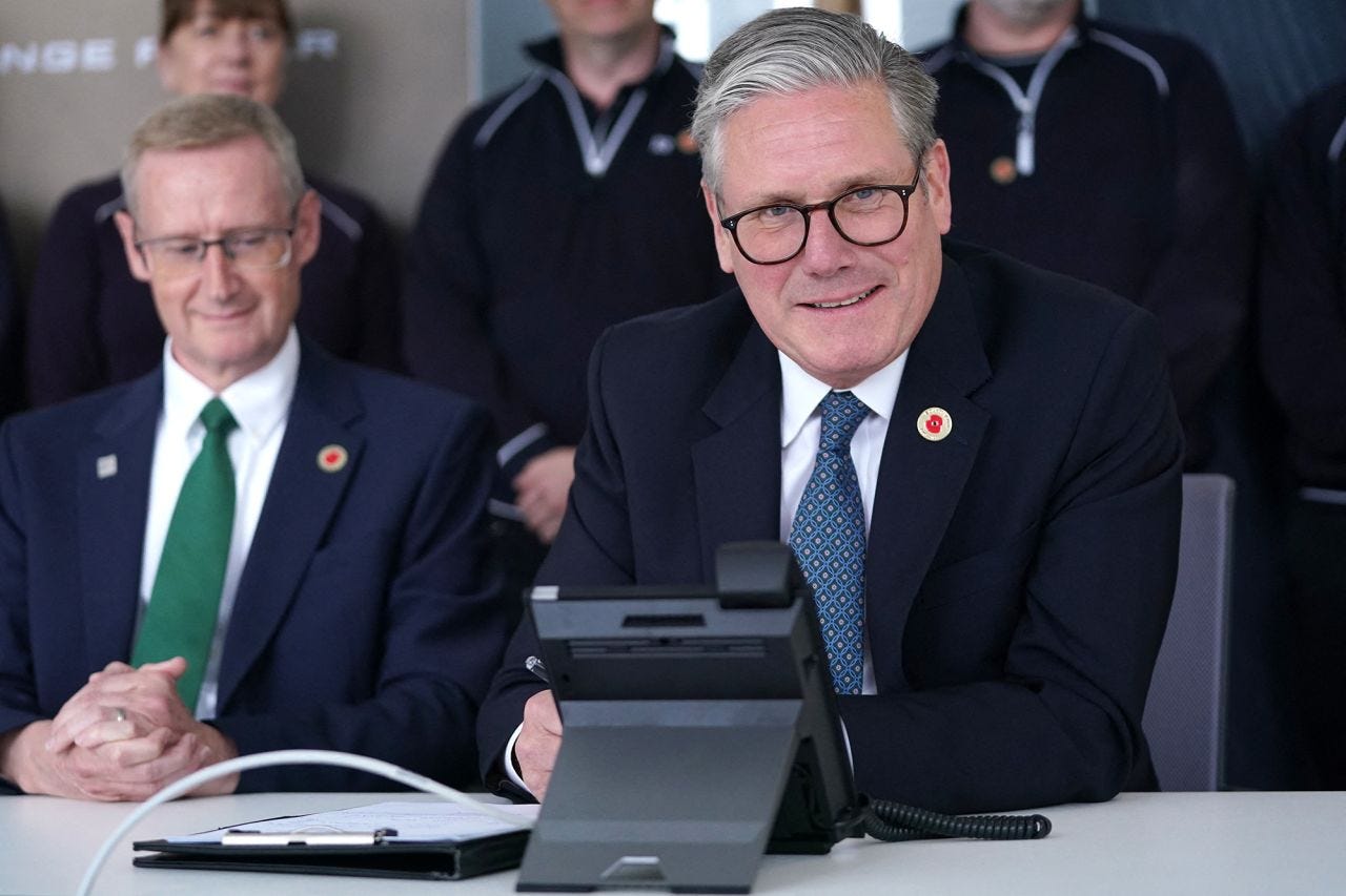 Britain's Prime Minister Keir Starmer smiles as he discusses a UK-US trade deal with US President Donald Trump over the phone at a car factory in the West Midlands on May 8. 