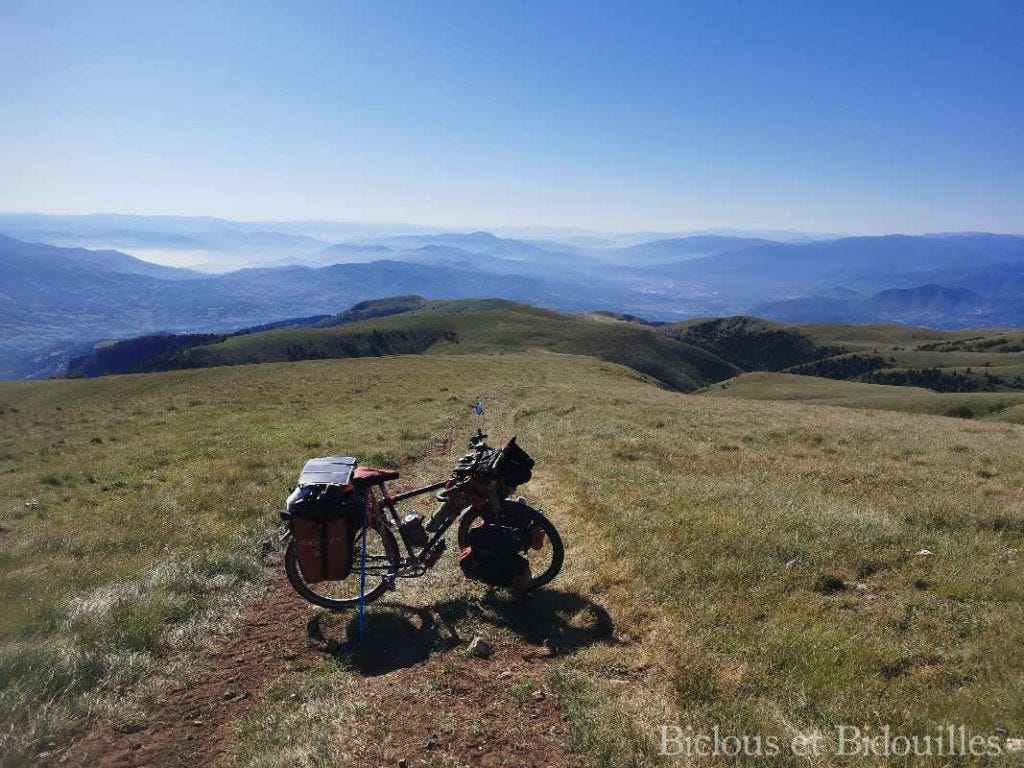 Vélo de voyage en haut d'une coline avec une vue panoramique