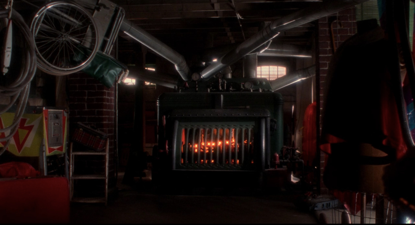 A screen grab from Home Alone featuring a fiery furnace in the middle of a cluttered basement.